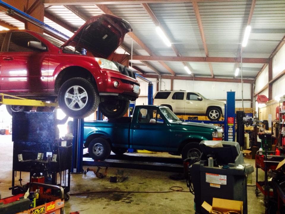 Vehicles on lifts inside the Dealer Solutions Automotive repair shop, which serves drivers from Riverside, TX